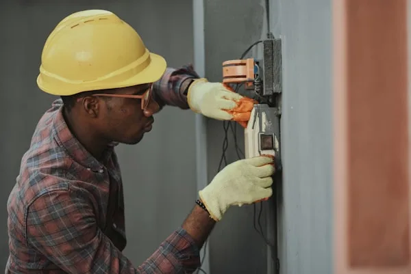 Technik montuje zabezpečovací panel na zeď